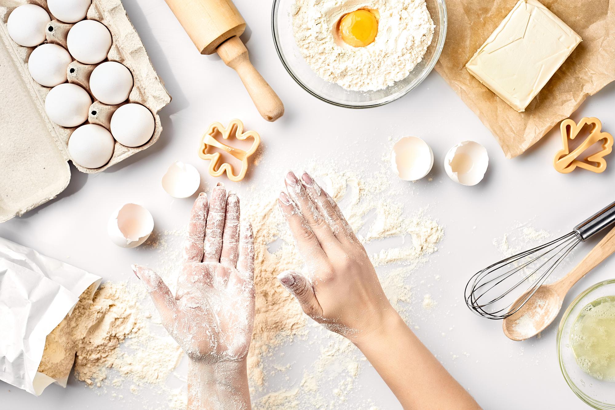 Hands kneading dough in a bright workshop