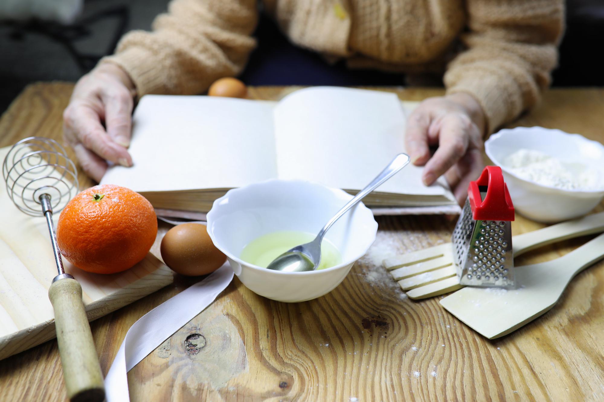Books of recipes and measured spoons on table